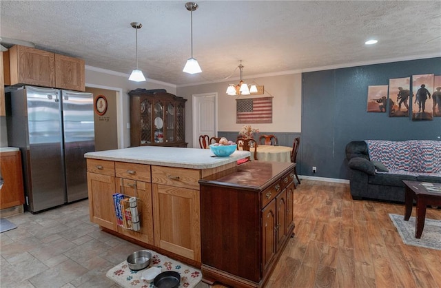 606 N Charles Ave, St James, MO 65559 - kitchen featuring freestanding refrigerator, a textured ceiling, a chandelier, crown molding, and a kitchen island
