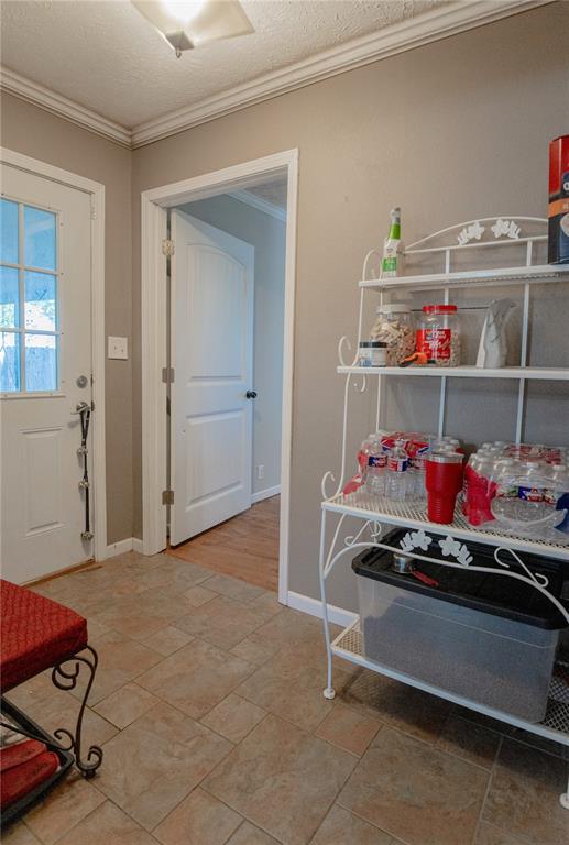 606 N Charles Ave, St James, MO 65559 - entryway featuring ornamental molding, baseboards, and a textured ceiling