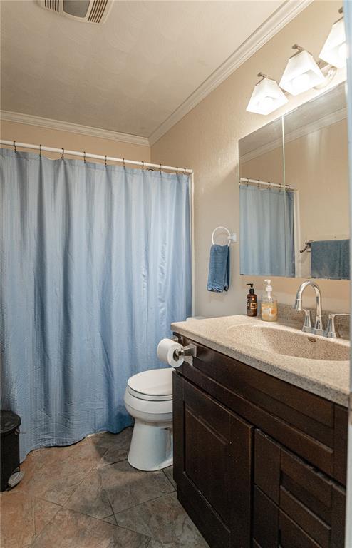 606 N Charles Ave, St James, MO 65559 - full bath with vanity, toilet, crown molding, and stone finish flooring