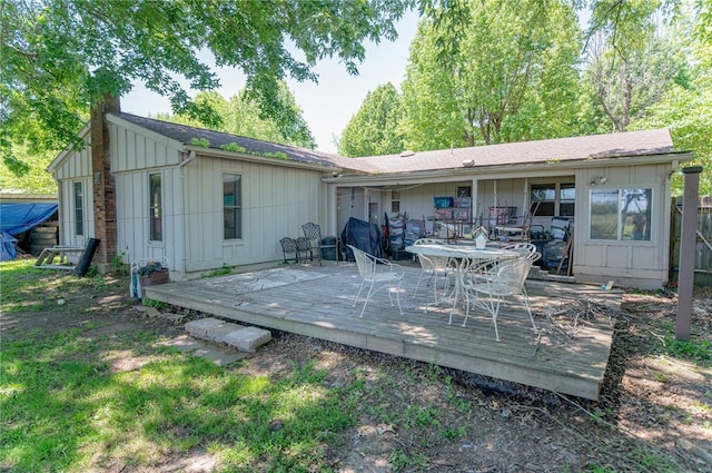606 N Charles Ave, St James, MO 65559 - rear view of property with board and batten siding, a chimney, and a deck