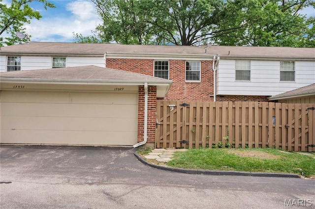 13489 Beaulac Dr, Chesterfield, MO 63141 - multi unit property featuring a gate, brick siding, an attached garage, and asphalt driveway