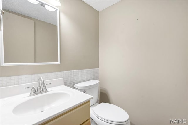 13489 Beaulac Dr, Chesterfield, MO 63141 - half bath featuring toilet, vanity, wainscoting, and tile walls
