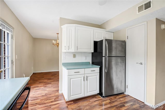 13489 Beaulac Dr, Chesterfield, MO 63141 - kitchen featuring freestanding refrigerator, tasteful backsplash, light wood finished floors, a chandelier, and white cabinets
