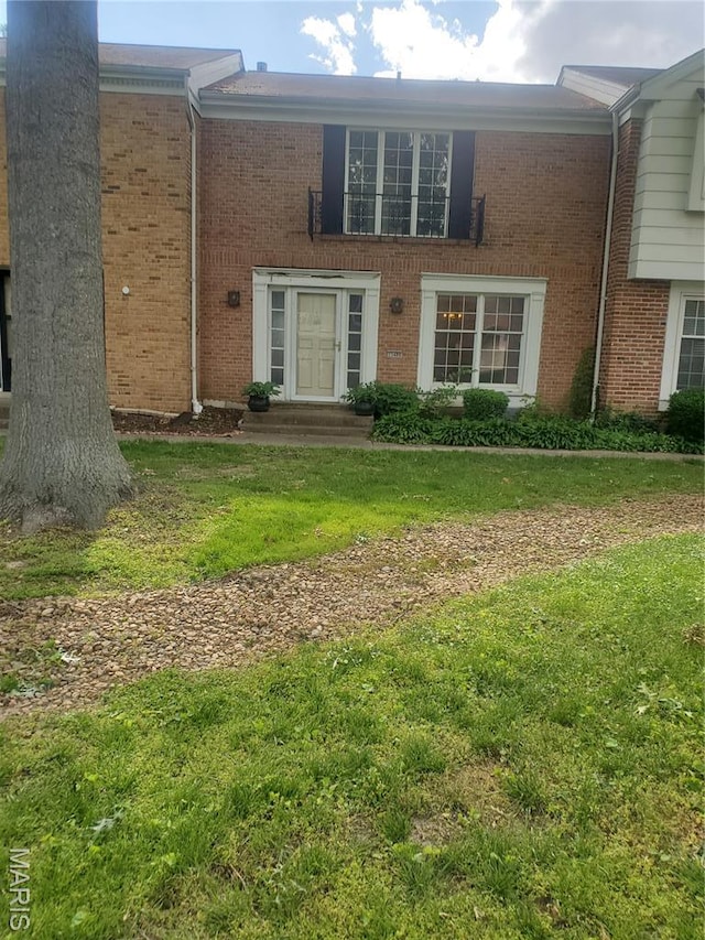 13489 Beaulac Dr, Chesterfield, MO 63141 - view of exterior entry with brick siding and a lawn