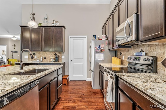 1930 Masters Dr, Festus, MO 63028 - kitchen featuring stainless steel appliances, a sink, dark brown cabinetry, dark wood-type flooring, and light stone countertops