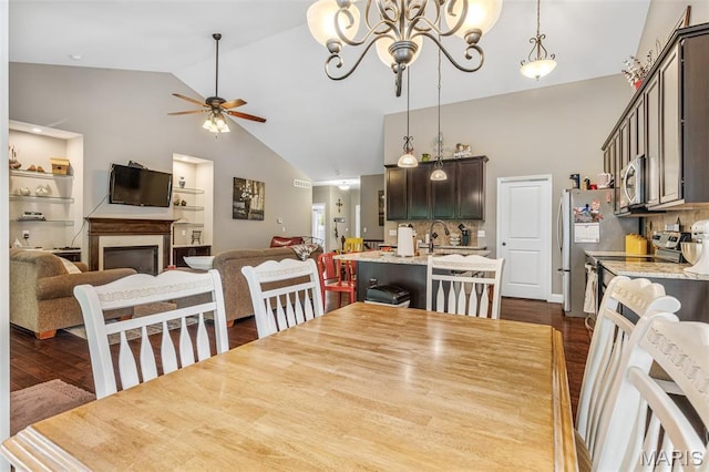 1930 Masters Dr, Festus, MO 63028 - dining room with dark wood finished floors, high vaulted ceiling, a ceiling fan, a chandelier, and a fireplace