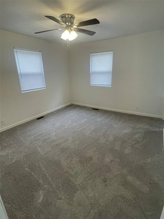 13103 Old 79, New London, MO 63459 - empty room featuring a ceiling fan, dark colored carpet, and baseboards