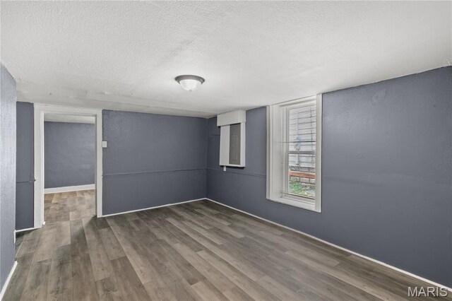 1217 E 5th St, Alton, IL 62002 - empty room featuring a textured ceiling, dark wood-style flooring, and baseboards