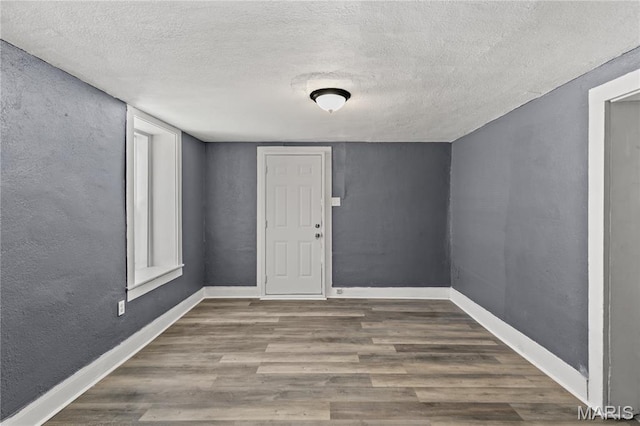1217 E 5th St, Alton, IL 62002 - empty room featuring wood finished floors, a textured ceiling, baseboards, and a textured wall