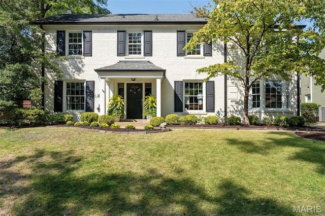 8033 Seminole Dr, Clayton, MO 63105 - colonial home featuring a front yard and brick siding