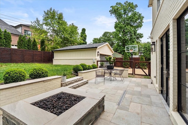 8033 Seminole Dr, Clayton, MO 63105 - fenced backyard featuring outdoor dining space, an outdoor fire pit, a patio area, and an outbuilding