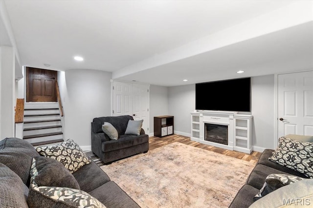 3536 Possum Ridge Dr, Imperial, MO 63052 - living area featuring stairway, wood finished floors, baseboards, a glass covered fireplace, and recessed lighting