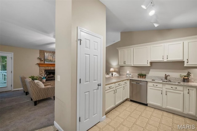 30 Citori Ct, Troy, MO 63379 - kitchen with stainless steel dishwasher, a sink, vaulted ceiling, a stone fireplace, and white cabinetry