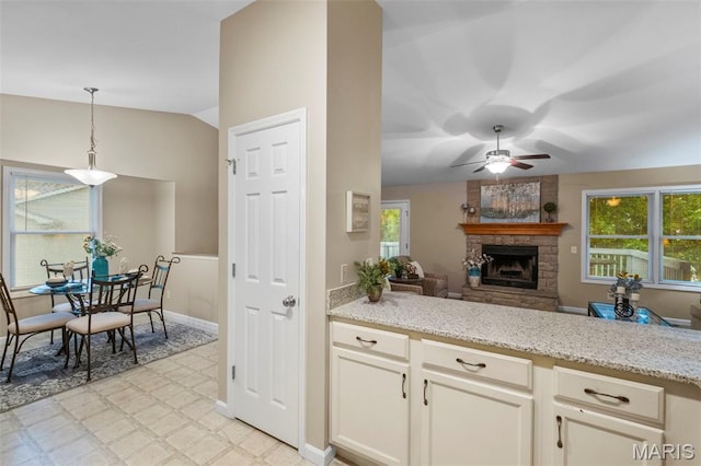30 Citori Ct, Troy, MO 63379 - kitchen featuring light flooring, a stone fireplace, ceiling fan, hanging light fixtures, and light stone countertops