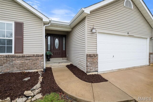 171 Majestic Lakes Blvd, Moscow Mills, MO 63362 - view of exterior entry with an attached garage, brick siding, and driveway