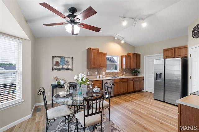 171 Majestic Lakes Blvd, Moscow Mills, MO 63362 - kitchen featuring appliances with stainless steel finishes, vaulted ceiling, rail lighting, a sink, and light wood-style flooring