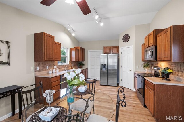 171 Majestic Lakes Blvd, Moscow Mills, MO 63362 - kitchen featuring appliances with stainless steel finishes, rail lighting, light wood-type flooring, light countertops, and lofted ceiling