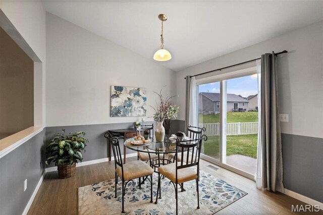 2231 Central Park Dr, Troy, MO 63379 - dining area with lofted ceiling, wood finished floors, and baseboards