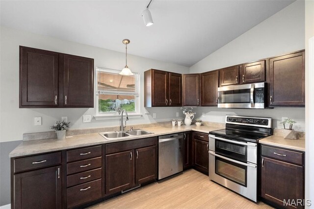 2231 Central Park Dr, Troy, MO 63379 - kitchen featuring stainless steel appliances, a sink, lofted ceiling, dark brown cabinetry, and light wood-type flooring