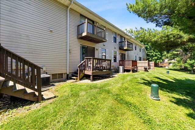 2032 New Sun Dr, Florissant, MO 63031 - back of house with a balcony, cooling unit, and a lawn