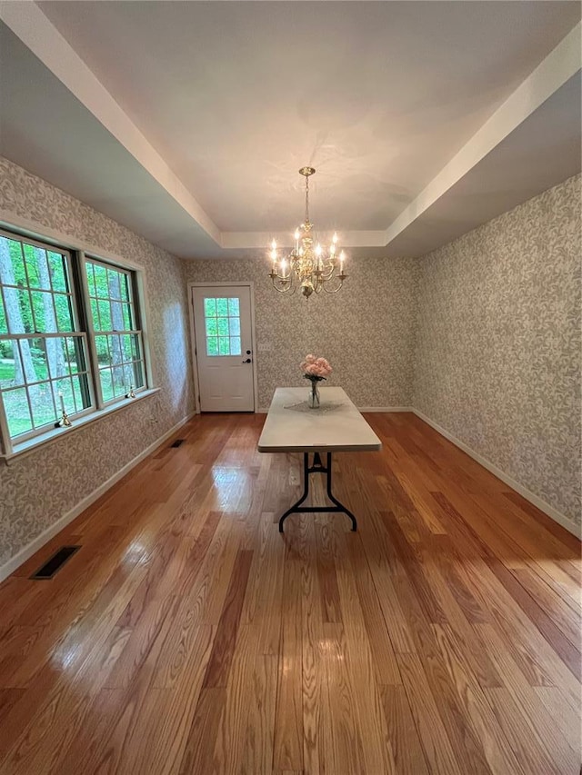 16453 Scenic Ridge Rd, Marthasville, MO 63357 - unfurnished dining area with wallpapered walls, wood finished floors, a tray ceiling, a chandelier, and baseboards