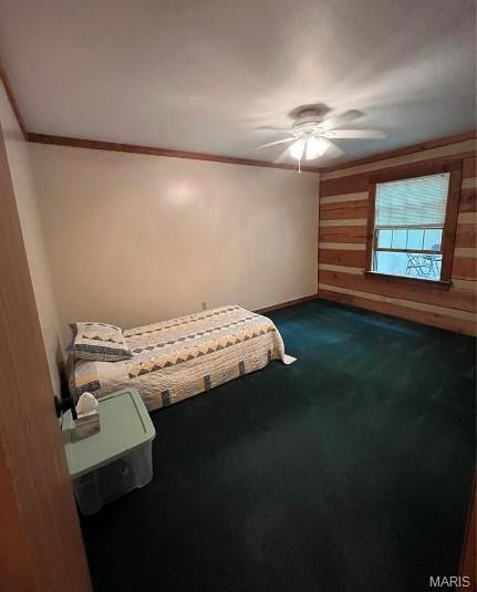 16453 Scenic Ridge Rd, Marthasville, MO 63357 - unfurnished bedroom featuring crown molding, dark carpet, a ceiling fan, and wooden walls