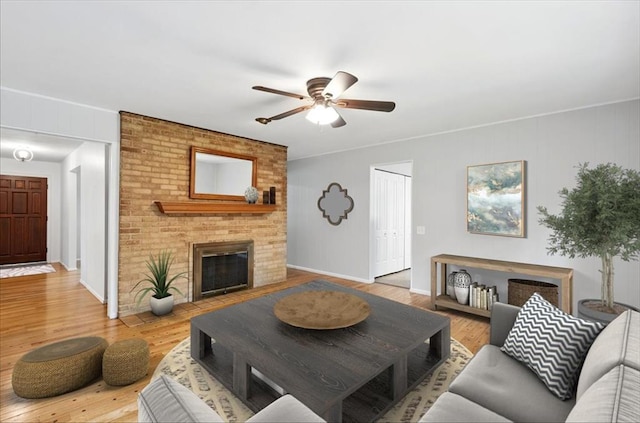 13105 Dartagnan Ct, Creve Coeur, MO 63141 - living room featuring a ceiling fan, wood finished floors, a brick fireplace, baseboards, and ornamental molding