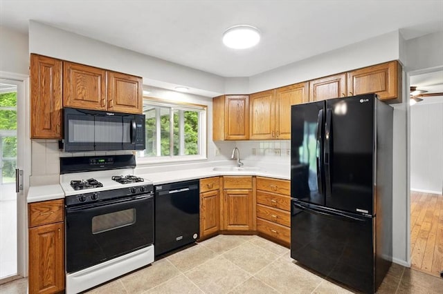 13105 Dartagnan Ct, Creve Coeur, MO 63141 - kitchen with black appliances, a sink, brown cabinetry, and backsplash
