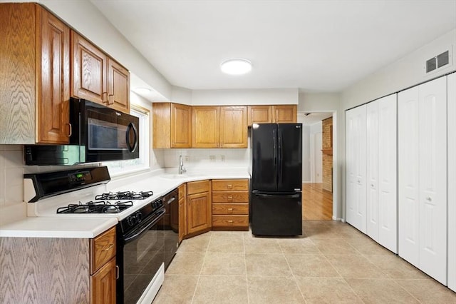 13105 Dartagnan Ct, Creve Coeur, MO 63141 - kitchen featuring black appliances, light countertops, brown cabinetry, and decorative backsplash