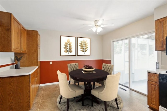 13105 Dartagnan Ct, Creve Coeur, MO 63141 - dining area with ceiling fan, wainscoting, and light tile patterned floors