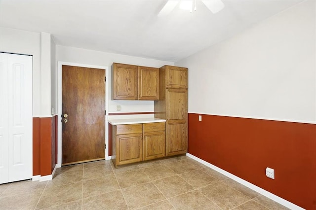 13105 Dartagnan Ct, Creve Coeur, MO 63141 - kitchen with brown cabinetry, baseboards, a ceiling fan, and light countertops
