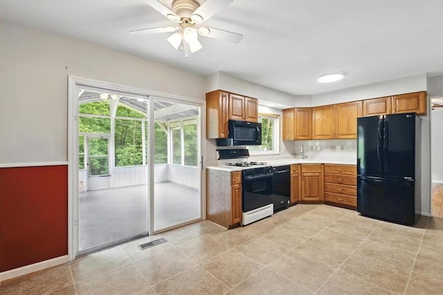 13105 Dartagnan Ct, Creve Coeur, MO 63141 - kitchen with black appliances, light countertops, ceiling fan, brown cabinetry, and baseboards