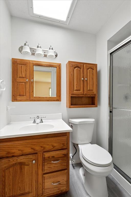 13105 Dartagnan Ct, Creve Coeur, MO 63141 - full bath featuring vanity, wood finished floors, a stall shower, and toilet