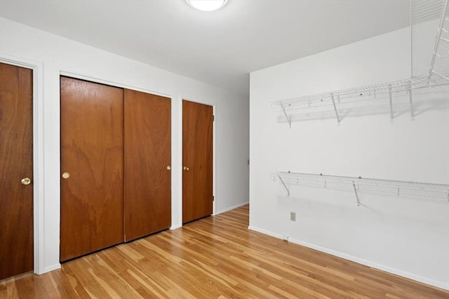 13105 Dartagnan Ct, Creve Coeur, MO 63141 - unfurnished bedroom featuring multiple closets, light wood-style floors, and baseboards