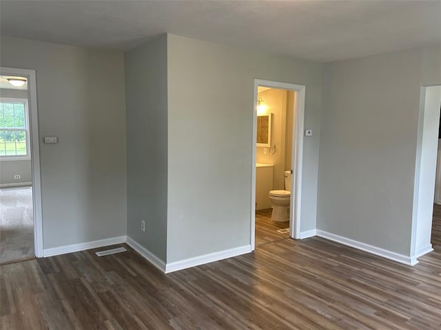 1910 E B St E, Belleville, IL 62221 - unfurnished bedroom featuring dark wood finished floors, baseboards, and ensuite bathroom