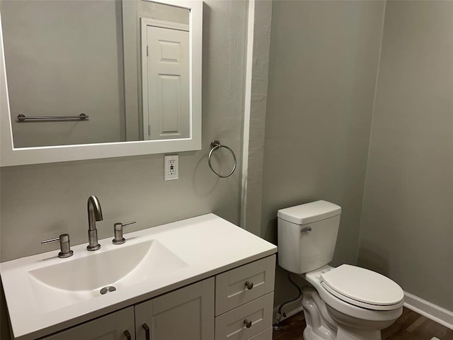 1910 E B St E, Belleville, IL 62221 - half bath featuring vanity, toilet, wood finished floors, and baseboards