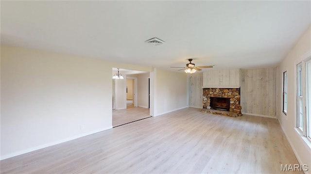 1350 Norwood Dr, Granite City, IL 62040 - unfurnished living room featuring light wood-style flooring, a ceiling fan, a stone fireplace, and a chandelier