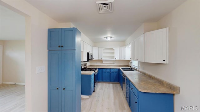 1350 Norwood Dr, Granite City, IL 62040 - kitchen with appliances with stainless steel finishes, blue cabinetry, light wood finished floors, and white cabinets