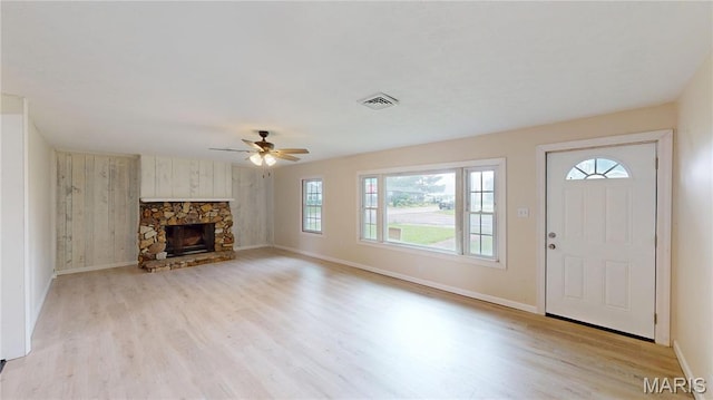 1350 Norwood Dr, Granite City, IL 62040 - unfurnished living room with plenty of natural light, light wood-type flooring, a ceiling fan, and a stone fireplace