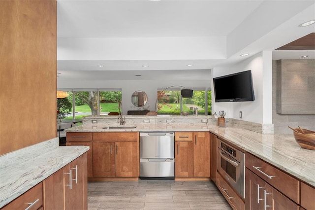 36 Stoneyside Ln, Olivette, MO 63132 - kitchen with stainless steel appliances, a sink, light stone countertops, brown cabinetry, and recessed lighting
