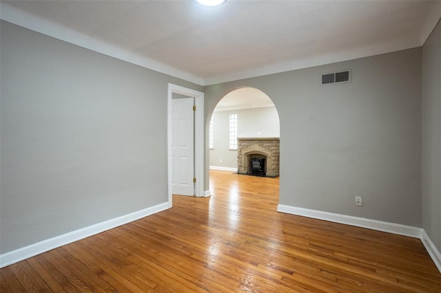 3210 Capehart Dr, Saint Louis, MO 63121 - empty room featuring light wood-style flooring, arched walkways, and baseboards