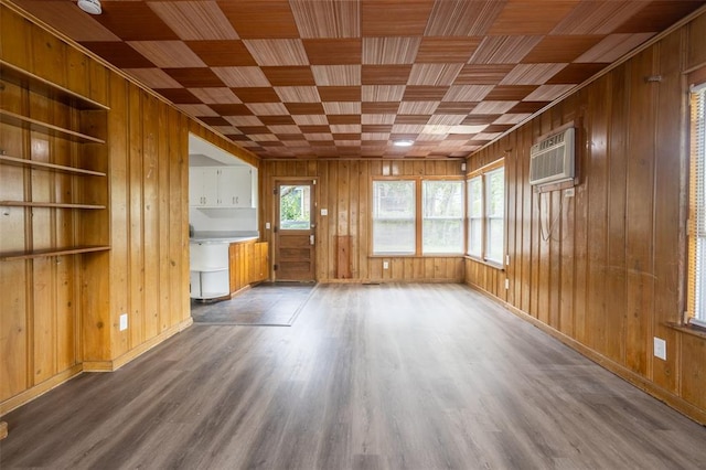 3210 Capehart Dr, Saint Louis, MO 63121 - unfurnished living room with wooden walls, wood finished floors, wooden ceiling, a wall unit AC, and baseboards