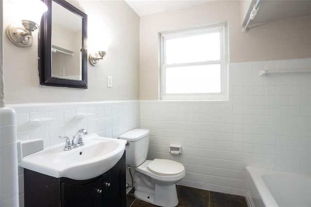 3210 Capehart Dr, Saint Louis, MO 63121 - full bath featuring tile walls, a tub to relax in, wainscoting, vanity, and toilet