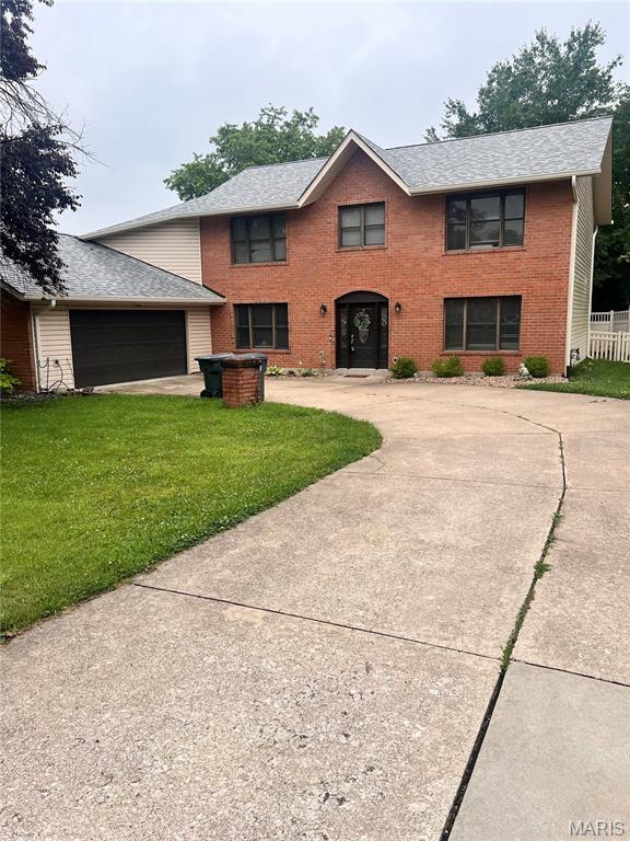 819 Colleen Dr, Ofallon, MO 63366 - view of front facade featuring driveway, a front lawn, an attached garage, brick siding, and a shingled roof