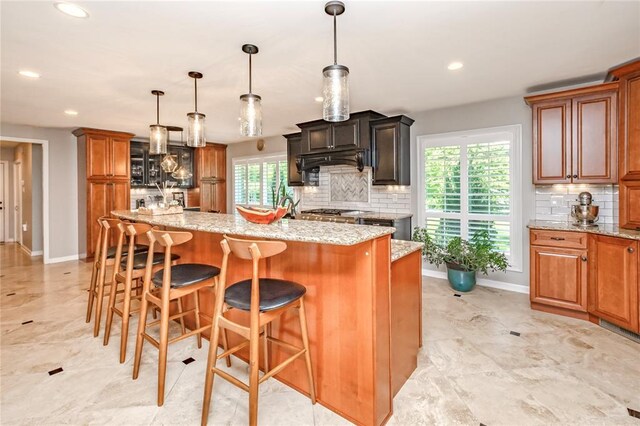 23 Vouga Ln, Frontenac, MO 63131 - kitchen featuring tasteful backsplash, healthy amount of natural light, light stone counters, recessed lighting, and baseboards