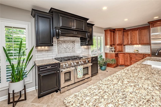 23 Vouga Ln, Frontenac, MO 63131 - kitchen with high quality appliances, a sink, light stone counters, decorative backsplash, and recessed lighting