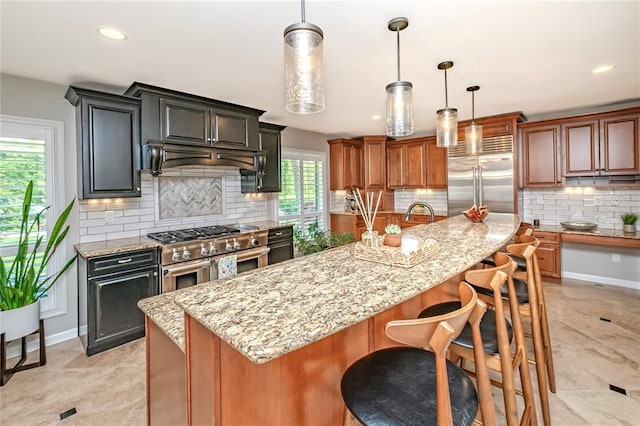 23 Vouga Ln, Frontenac, MO 63131 - kitchen with high end appliances, decorative backsplash, light stone countertops, recessed lighting, and decorative light fixtures