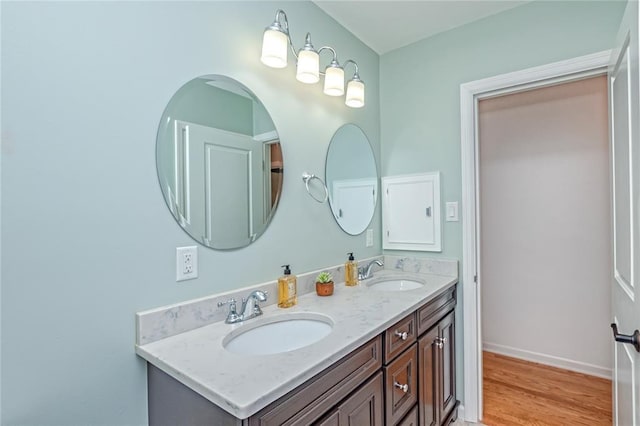 23 Vouga Ln, Frontenac, MO 63131 - bathroom with double vanity, wood finished floors, and baseboards