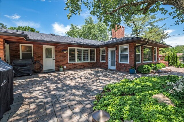 23 Vouga Ln, Frontenac, MO 63131 - back of property with a chimney, a patio, and brick siding