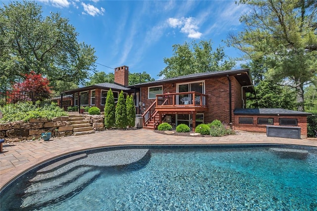 23 Vouga Ln, Frontenac, MO 63131 - back of property with stairs, brick siding, a chimney, a wooden deck, and an outdoor pool